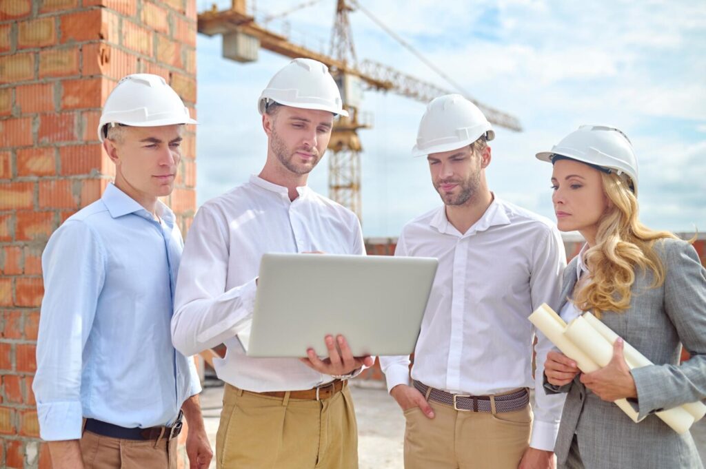 mujeres-hombres-mirando-portatil-construccion_259150-57850